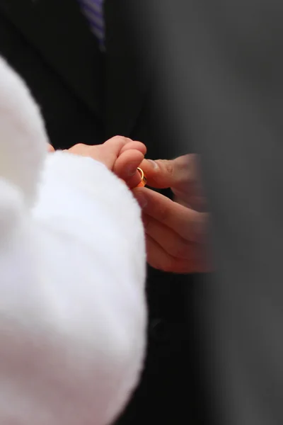 Groom met une bague dorée sur le doigt des mariées — Photo