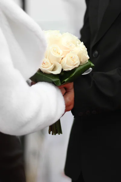 Bride and groom holding wedding flowers — Stock Photo, Image