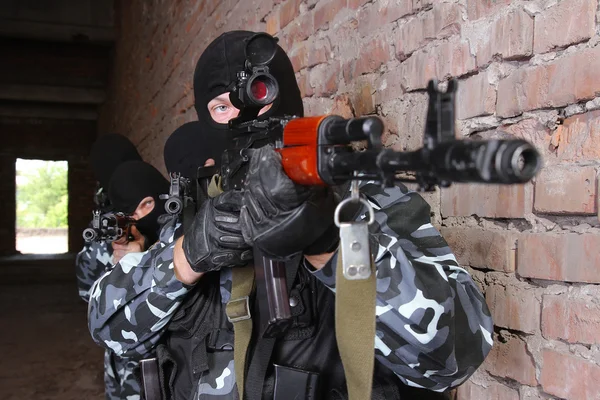 Soldados em máscaras pretas com armas — Fotografia de Stock