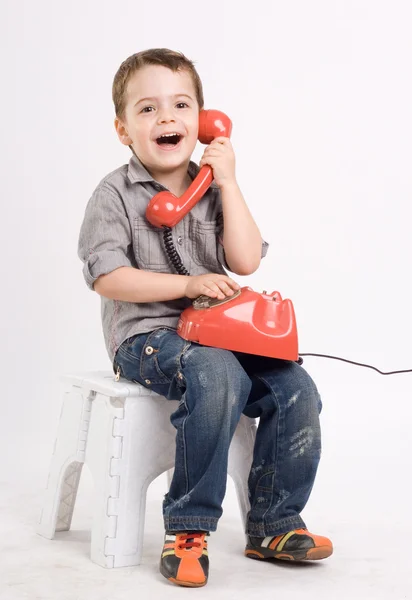 Lite gay pojke talar på retro telefon. — Stockfoto