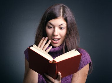 Surprised woman reading a book. clipart