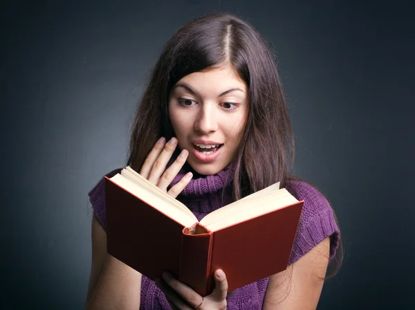 Surprised woman reading a book. — Stock Photo, Image