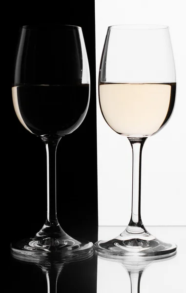 Δύο ποτήρια λευκό κρασί σε αντίθεση φόντο. — Φωτογραφία Αρχείου