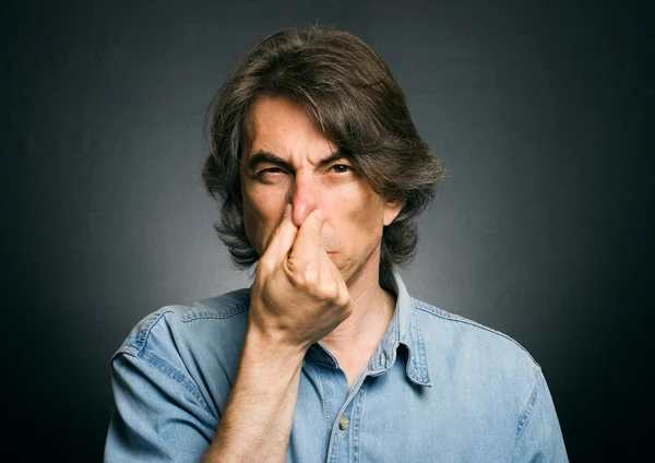 Man 's nose clamping hands of a bad smell. — Stock Photo, Image