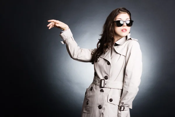 Beautiful woman in the raincoat and sunglasses — Stock Photo, Image