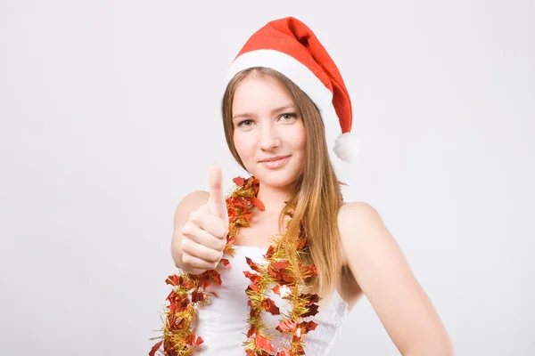 Başparmak gösterilen Noel Baba şapkalı kız. — Stok fotoğraf
