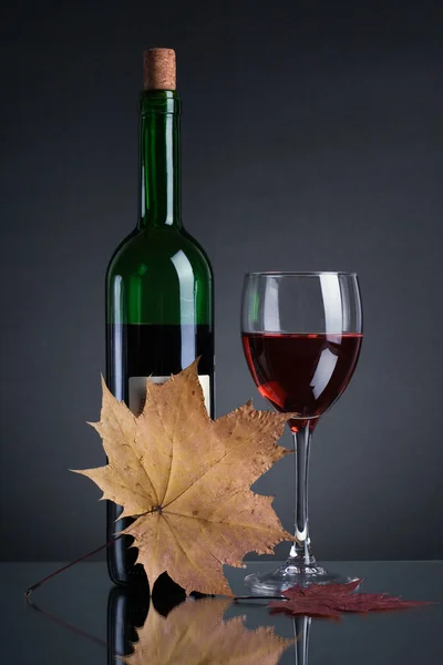 Бутылка с красным вином и бокалом — стоковое фото