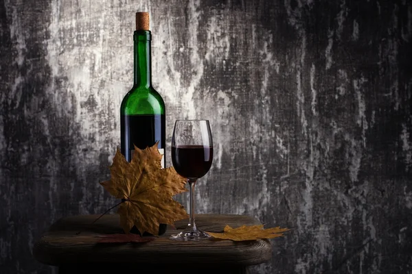 Bottle with red wine and glass on a old stone — Stock Photo, Image