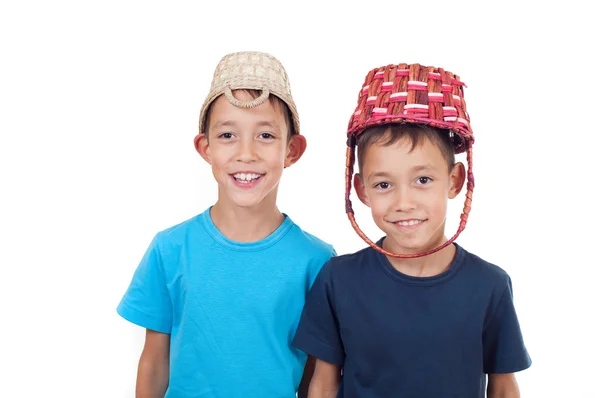 Twins playing with wicker baskets — Stock Photo, Image