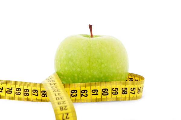 Зеленое яблоко с желтой измерительной лентой — стоковое фото