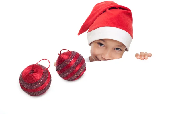 Мальчик в красной шляпе с двумя рождественскими шарами — стоковое фото