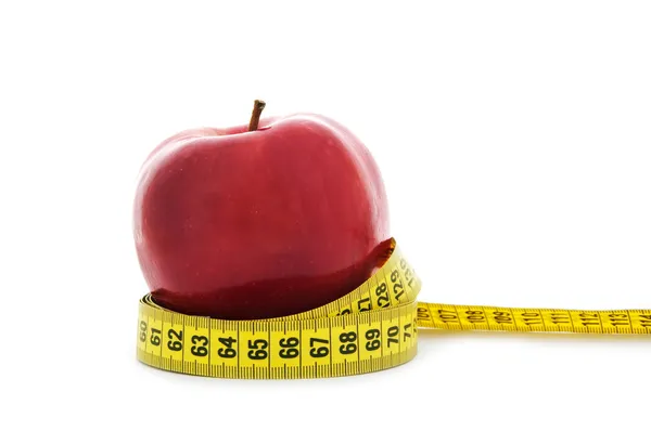 Яблоко с желтой измерительной лентой — стоковое фото