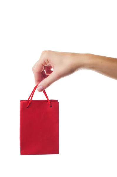 Mano femenina sosteniendo bolsa de regalo roja — Foto de Stock