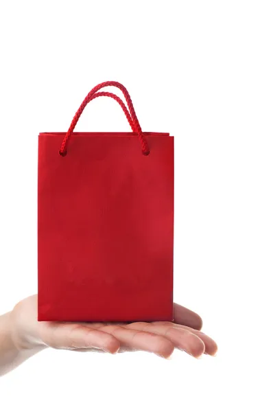 Mano femenina sosteniendo bolsa de regalo roja — Foto de Stock