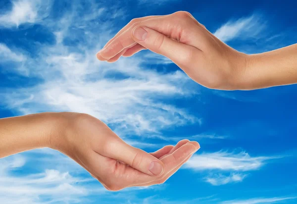 Mãos femininas sobre o céu azul com nuvens — Fotografia de Stock