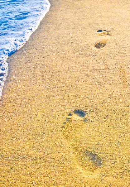 Следы на песке с пеной — стоковое фото