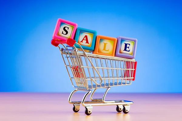 Mini shopping cart against gradient background — Stock Photo, Image