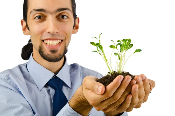 Ung student håller gröna plantor på vit — Stockfoto