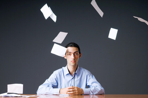 Летающая бумага и бизнесмен в офисе