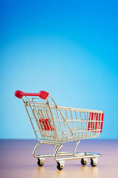 Mini shopping cart against gradient background — Stock Photo, Image