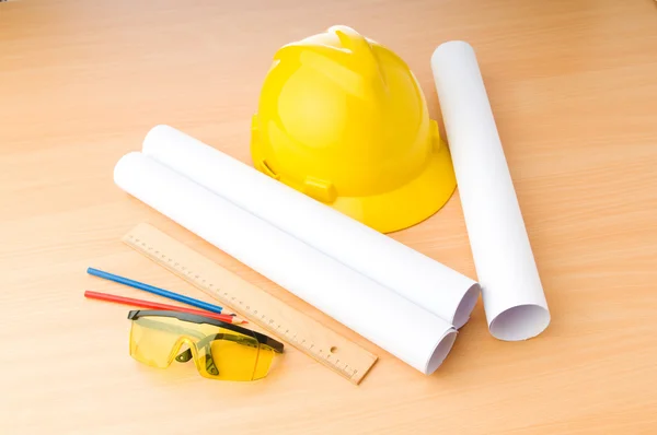 Drawings and hard hat on the desk — Stock Photo, Image