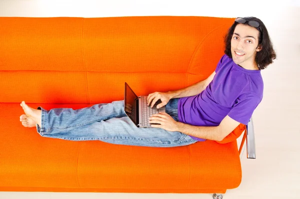 Estudante trabalhando com laptop sentado no sofá — Fotografia de Stock