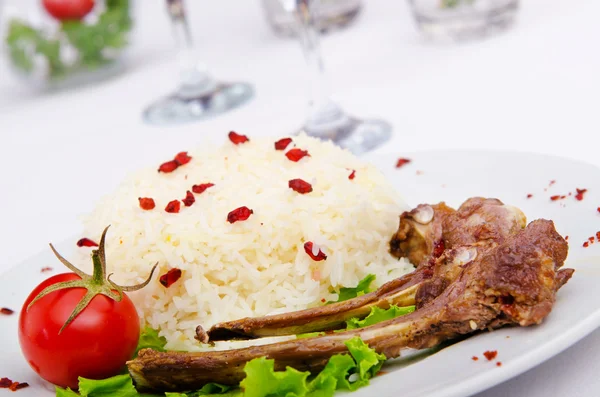 Costillas de cordero con arroz servidas en el plato —  Fotos de Stock