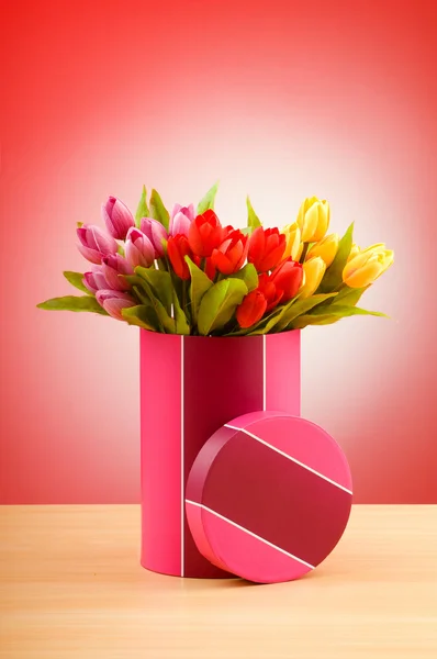 Geschenkbox und Tulpen vor Gradientenhintergrund — Stockfoto