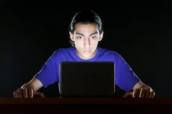 Хакер сидит в темной комнате — стоковое фото