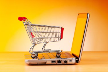 Internet online shopping concept with computer and cart clipart