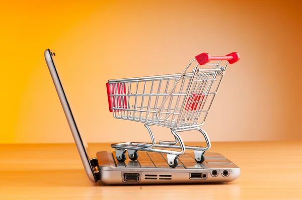 Shopping online with computer and cart Royalty Free Stock Photos