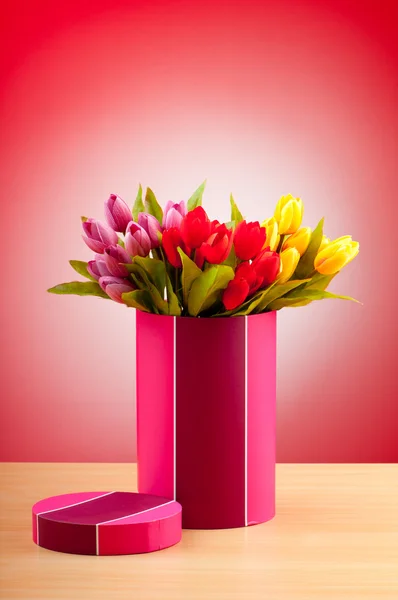 Gavekasse og tulipaner mot helningsbakgrunn – stockfoto