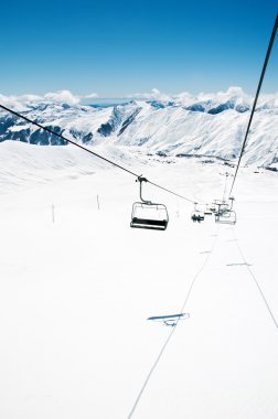Aydınlık kış gününde kayak kaldırma koltukları