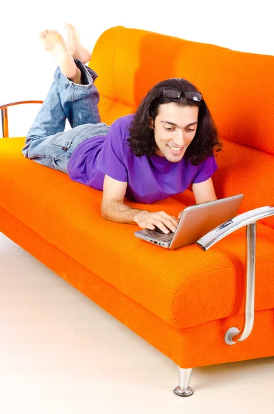 Étudiant travaillant avec un ordinateur portable assis sur un canapé — Photo
