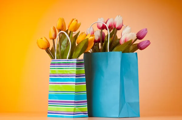 Тюльпаны в сумке на фоне градиента — стоковое фото