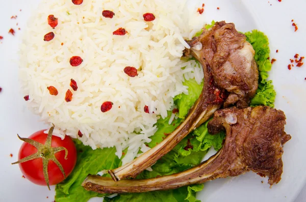 Costillas de cordero con arroz servidas en el plato —  Fotos de Stock