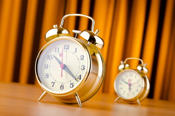 Alarm clock against curtain Stock Photo