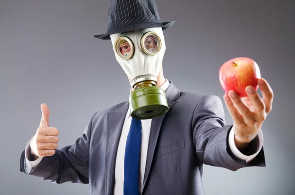 Empresario con máscara de gas y manzana —  Fotos de Stock