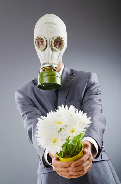Biznesmen z maski gazowe i kwiaty — Zdjęcie stockowe