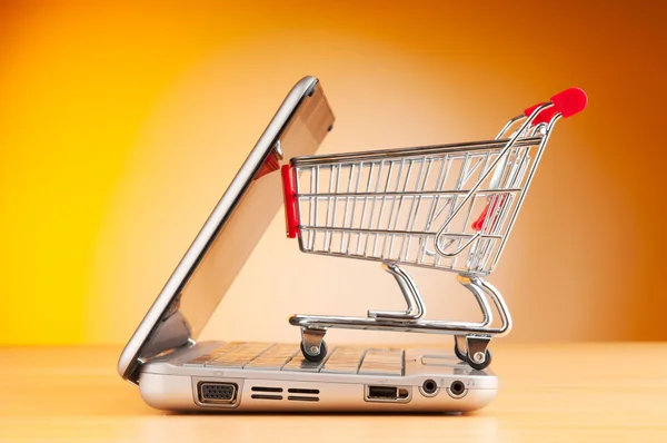 Shopping online with computer and cart Stock Image