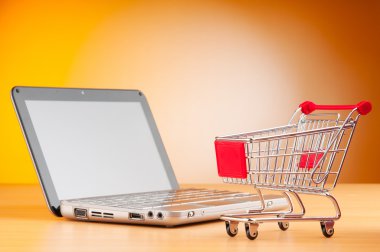 Shopping online with computer and cart clipart