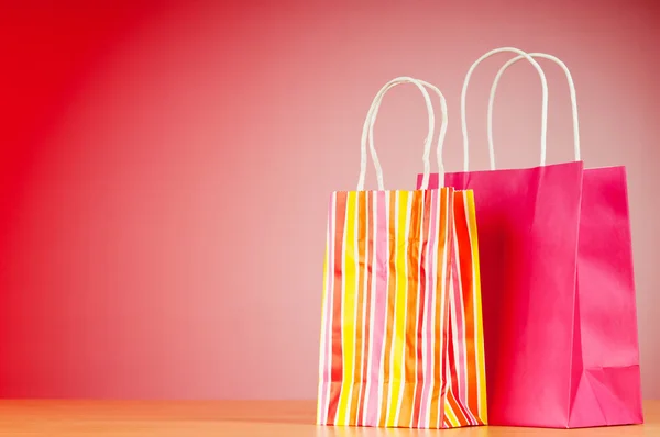Kleurrijke papier boodschappentassen tegen achtergrond met kleurovergang — Stockfoto