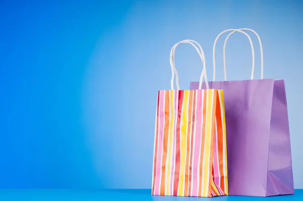 Barevné papírové nákupní tašky proti barevných přechodů — Stock fotografie