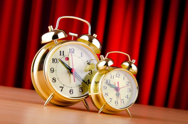 Alarm clock against curtain — Stock Photo, Image