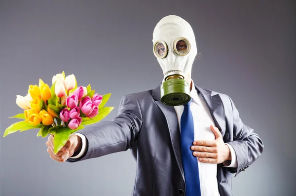 Affärsman med gasmask och blommor — Stockfoto
