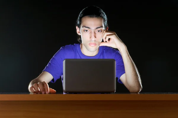 Хакер сидит в темной комнате — стоковое фото