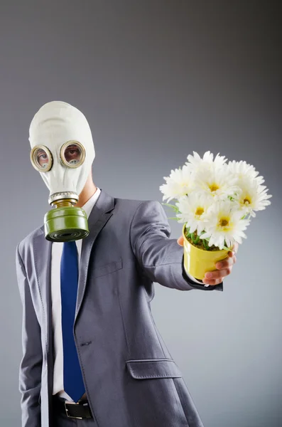Affärsman med gasmask och blommor — Stockfoto