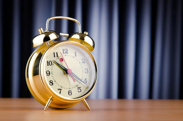 Alarm clock against curtain — Stock Photo, Image