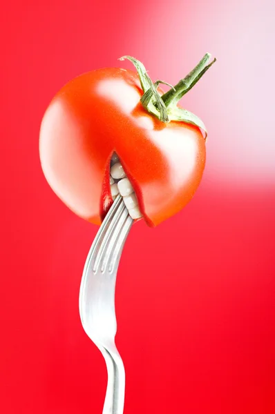 Tomate rouge avec bouche sur fond rouge — Photo