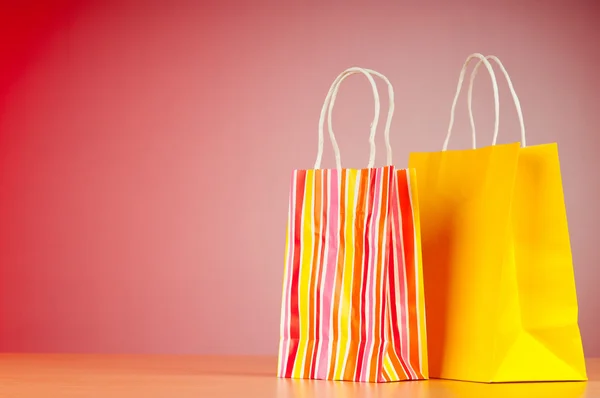 Färgglada papper shoppingkassar mot tonad bakgrund — Stockfoto